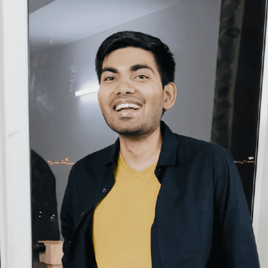 Shivam Kumar smiling in a casual dark overshirt and mustard tee